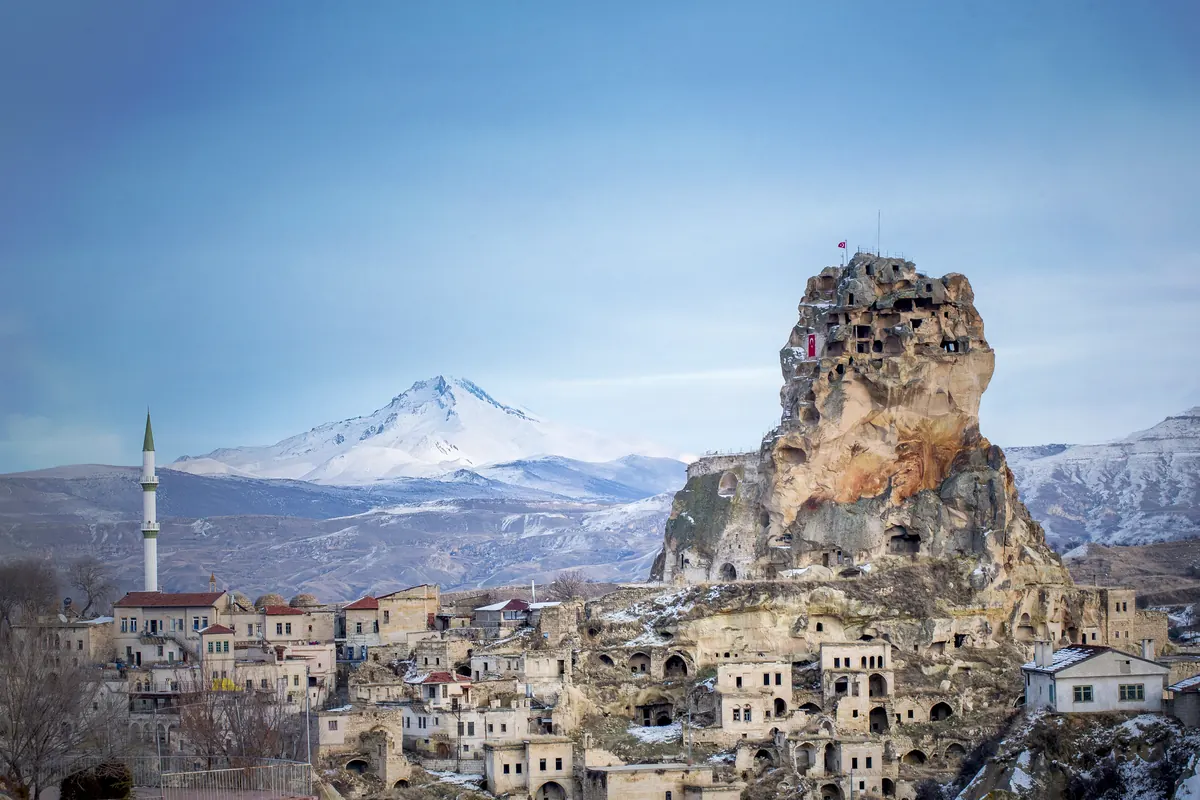 Kastil Ortahisar dengan Gunung Erciyes bersalju di belakangnya